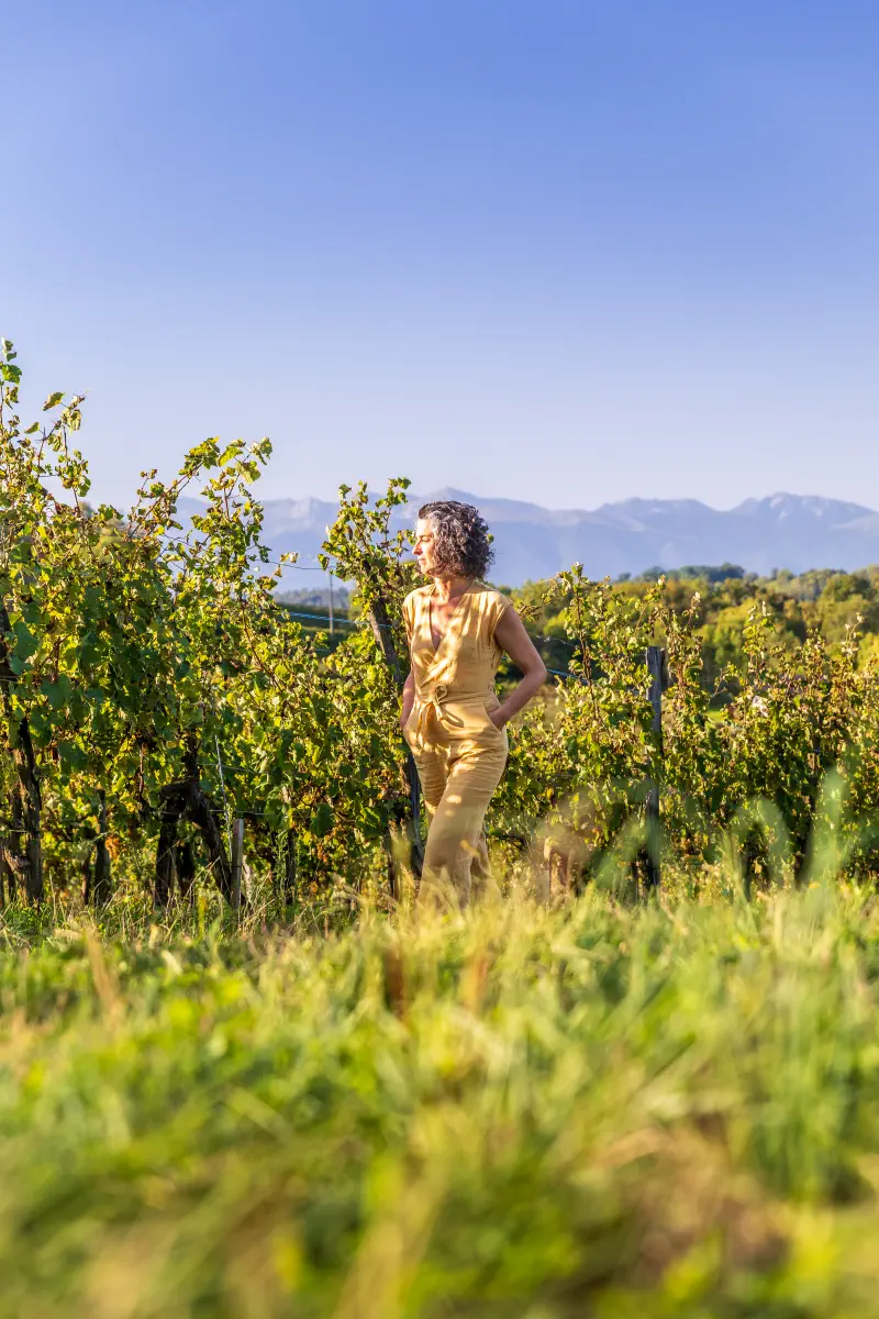 Christine Irabola, consultante SEO et podcast, sur les côteaux de Jurançon avec les Pyrénées en fond